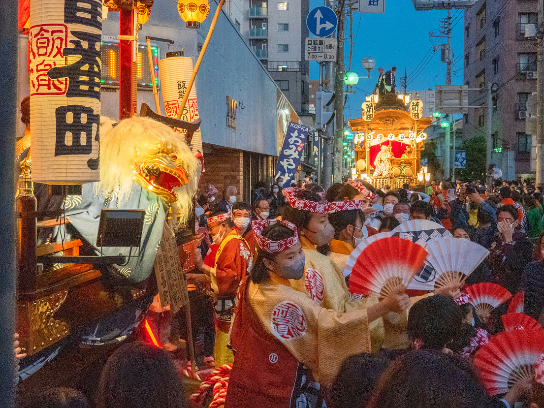 飯能まつりの山車から獅子舞が顔をのぞかせて人波を眺めている写真